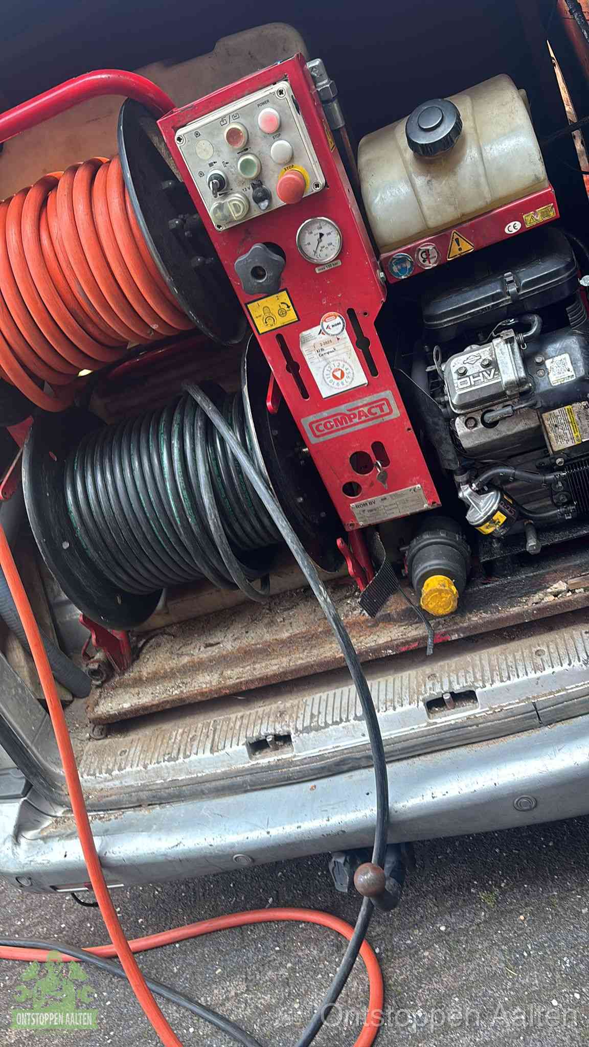 Een rood hogedruk-rioolreinigingstoestel met slangen in de laadbak van de bedrijfsbus, apparatuur voor een hardnekkige wc-verstopping in Aalten