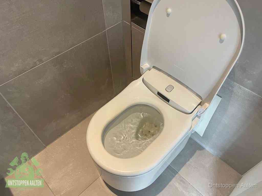 Een toiletpot vol troebel water met drijvend papier en restanten, de meest voorkomende oorzaak van een verstopte wc in Aalten