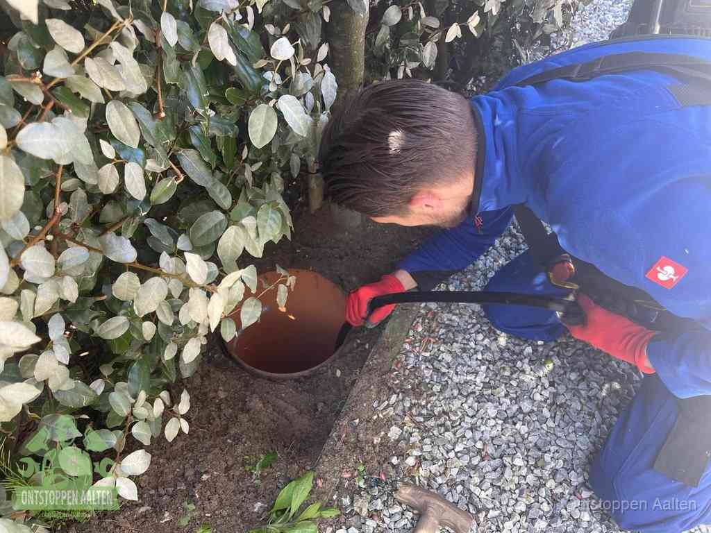 Monteur reinigt een rioolput met een slang, periodieke rioolreiniging in Aalten
