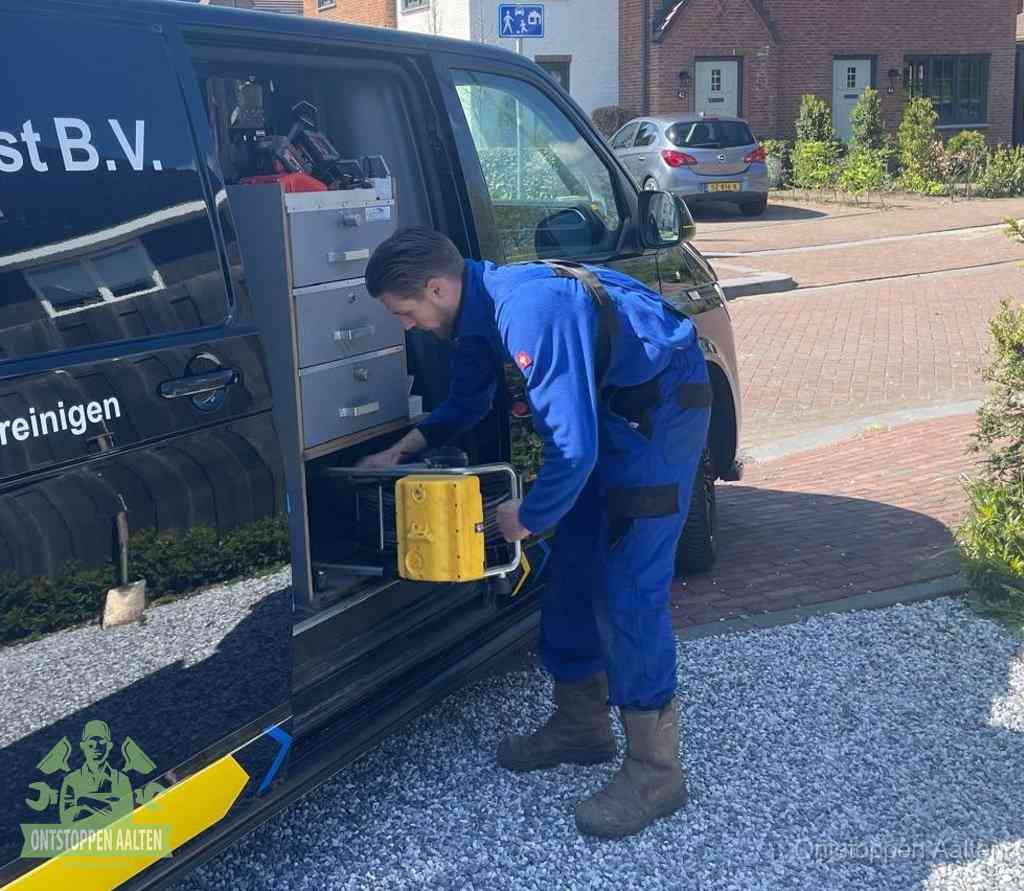 Een monteur pakt apparatuur uit de bedrijfsbus voor service aan huis, het moment om een professional in te schakelen voor een verstopte wc in Aalten