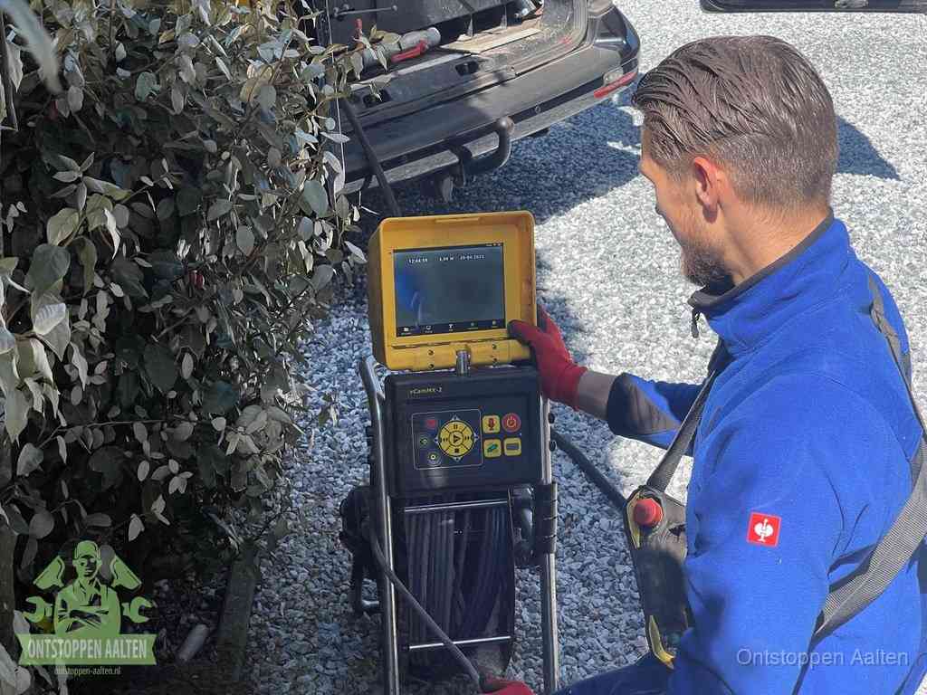 Monteur bedient een rioolinspectiecamera met monitor voor rioolinspectie in Aalten
