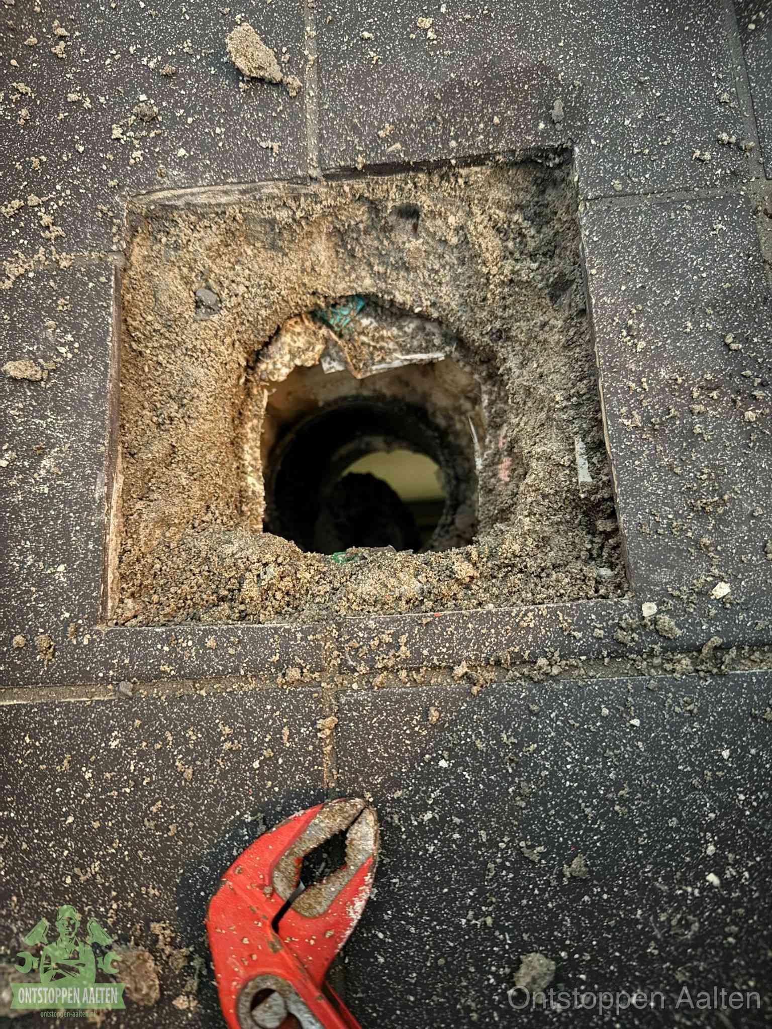 Geopend rioolputje op de erfgrens dat laat zien wie eigenaar is van de riolering in Aalten
