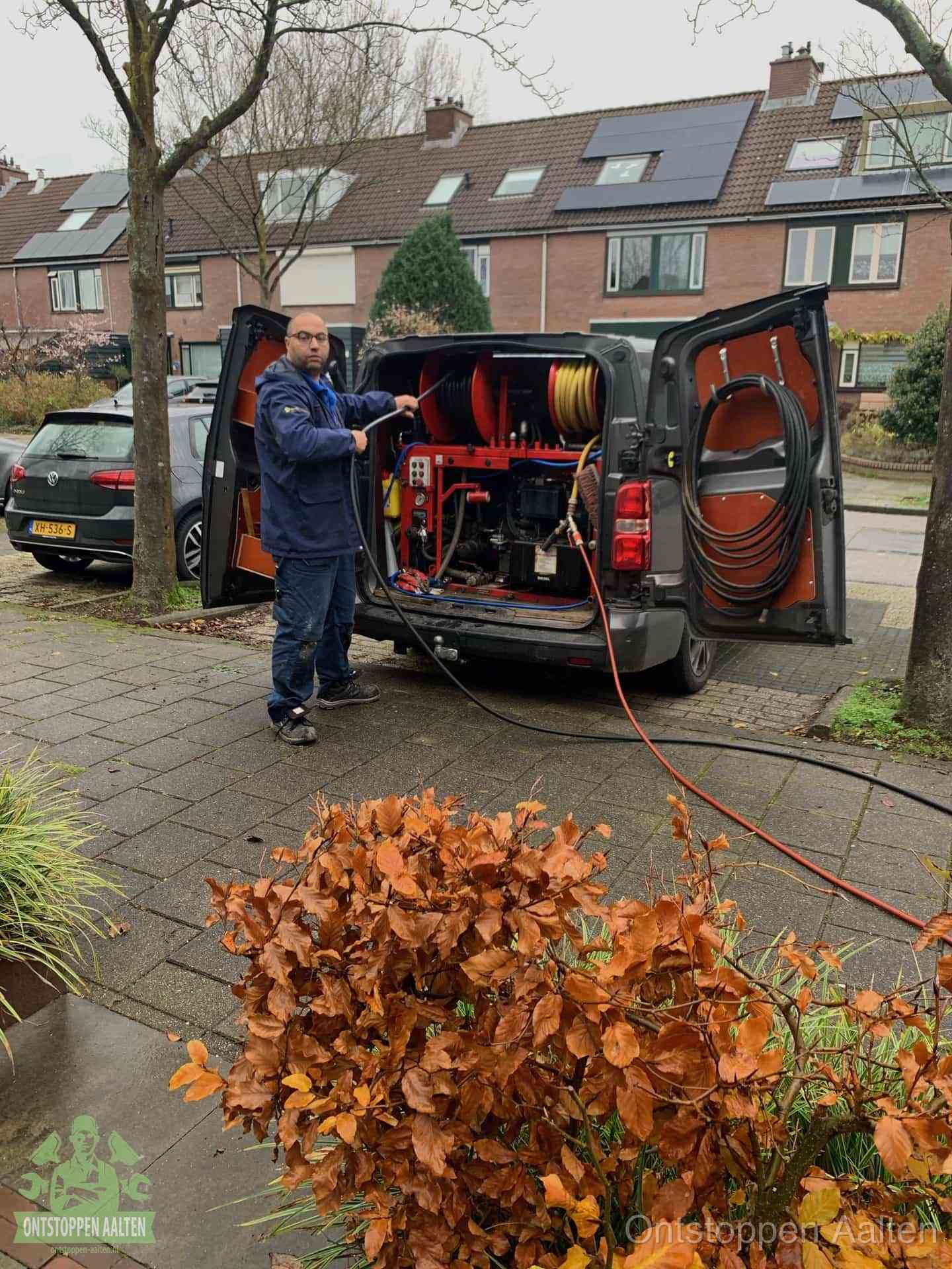 Monteur met rioolreinigingsbus levert rioolservice in de wijk in Aalten