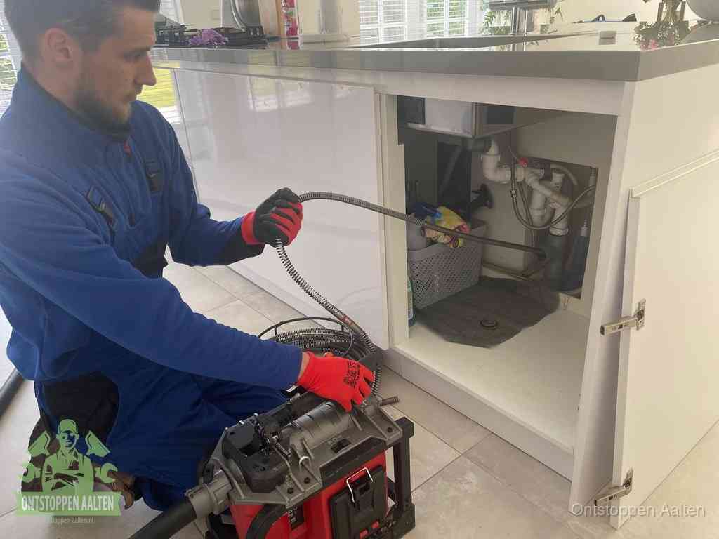 Een monteur reinigt de keukenafvoer grondig met een veermachine om terugkerende gootsteenverstoppingen te voorkomen in Aalten