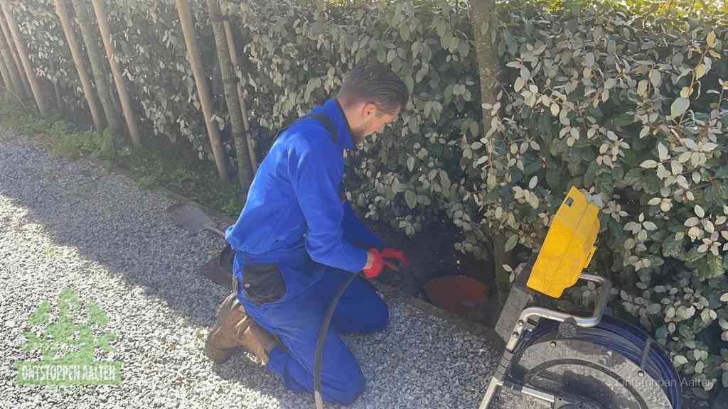 Monteur aan het werk bij een rioolput, de werkwijze voor riool ontstoppen in Aalten