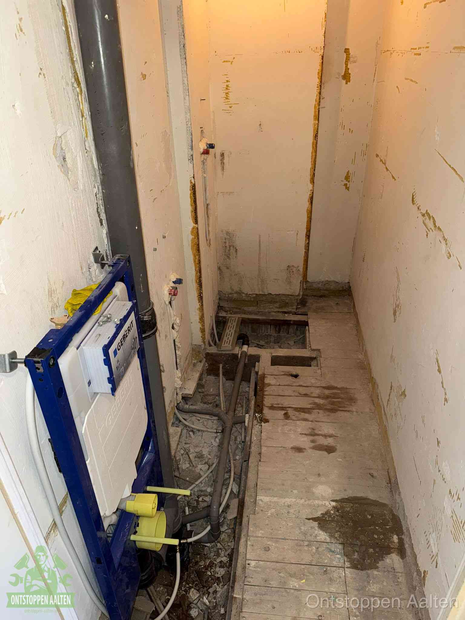 Een opgebroken toiletruimte tijdens renovatie met een Geberit inbouwreservoir en blootliggende oude afvoerleidingen, typisch voor oudere woningen in Aalten